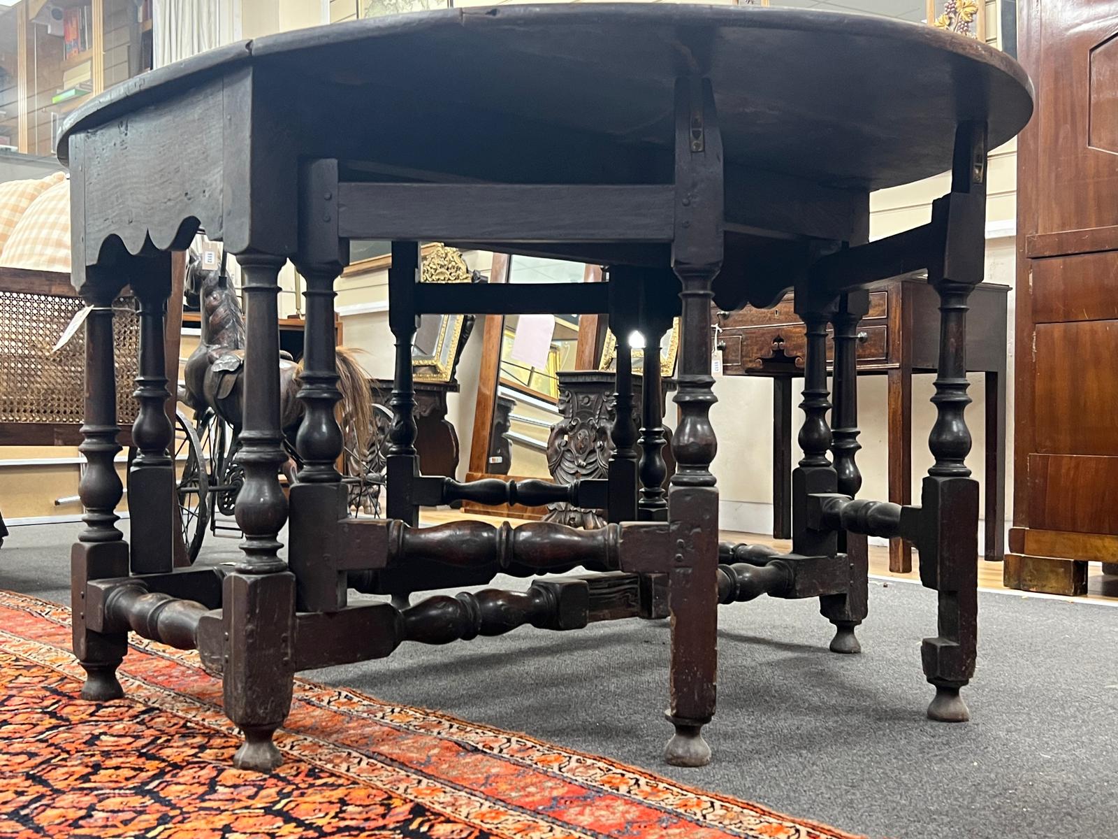 An 18th century oval oak gateleg dining table with turned under frame, width extended 146cm, depth 114cm, height 74cm